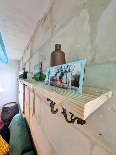 une étagère sur un mur avec un vase sur lui dans l'établissement La rose d'Alfred, à Chédigny