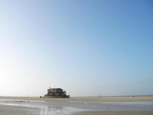 a building sitting on the beach next to the ocean at Hotel Landhaus Ellerbrock in Sankt Peter-Ording