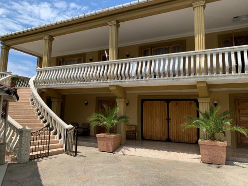 a house with a staircase and two potted plants at Giorgi's Guesthouse in K'obulet'i