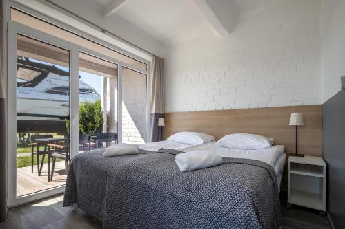 a bedroom with a bed and a large window at Smiltynės Jachtklubas in Klaipėda
