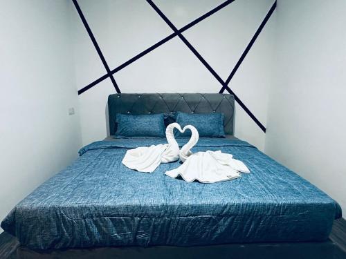 a bed with two towels in the shape of a heart at Kuu Inn Hotel in Arau