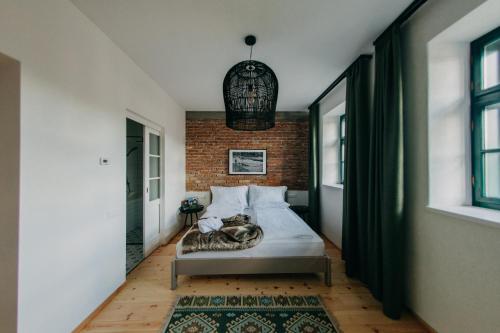 a bedroom with a bed and a brick wall at Ugron Castle Fiatfalva in Cristuru Secuiesc