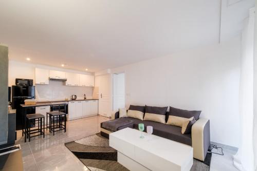 un salon avec un canapé et une cuisine dans l'établissement Batié - Appt 4 personnes à Mulhouse, à Mulhouse