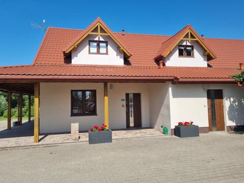 a white house with a red roof at Zygi Ranch Noclegi in Ostrów Mazowiecka