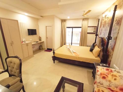 a room with a bed and a couch and a tv at The Piku's in Digha