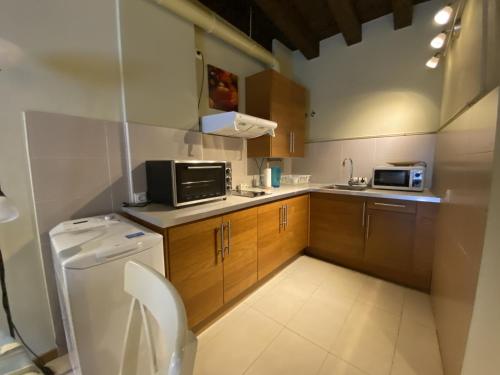 a small kitchen with a toilet and a sink at Refitolería Apartamentos in Segovia