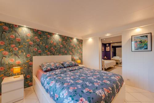 une chambre avec un lit avec un papier peint fleuri dans l'établissement L'Oasis - Disney 10min - Paris - Vallée Village - Parking, à Chessy