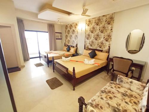 a hotel room with two beds and a couch at The Piku's in Digha