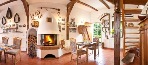 een woonkamer met een open haard en een tafel en stoelen bij Pension zur Scheune in Plau am See