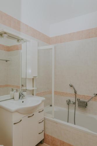 a white bathroom with a sink and a shower at Villa Danex in Umag
