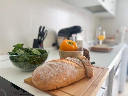 a loaf of bread and a bowl of vegetables on a kitchen counter at CerezasHomes3 in Jaraiz de la Vera