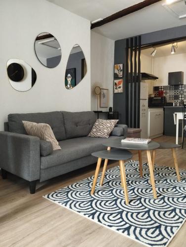 a living room with a gray couch and a rug at Appartement ELYNE Quartier des Templiers à 400m de la mer in Saint-Raphaël