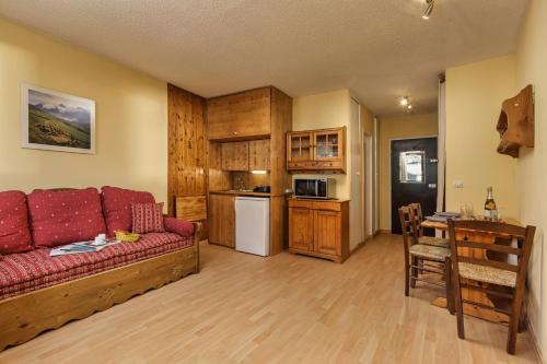 un salon avec un canapé rouge et une cuisine dans l'établissement Chamonix Sud - Bâtiment G 45 - Happy Rentals, à Chamonix-Mont-Blanc