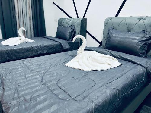 two swans sitting on a bed in a room at Kuu Inn Hotel in Arau