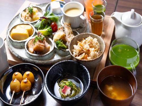a wooden table with plates of food and drinks at APA Hotel Yodoyabashi Kitahama Ekimae in Osaka