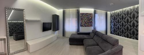 ein Wohnzimmer mit einer Couch und einem Spiegel in der Unterkunft Nuevo Apartamento en el centro by Lujo in Pamplona