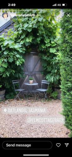 a picture of a garden with a table and chairs at Elm Cottage Barn in Oatlands