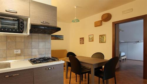 a kitchen and dining room with a table and a microwave at Monteverde in Latronico