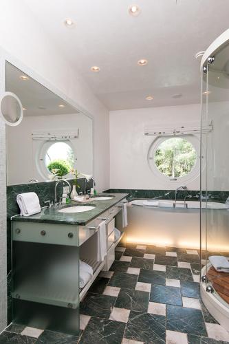 a bathroom with two sinks and a bath tub at Hotel Fährhaus in Munkmarsch