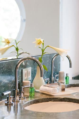 a bathroom sink with two faucets on a counter at Hotel Fährhaus in Munkmarsch