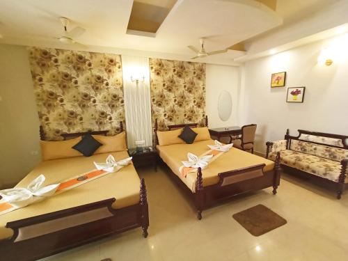 a bedroom with two beds and a couch at The Piku's in Digha