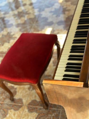 a piano with a red chair sitting next to it at Oceanfront Escape in Zanzibar in Bungi