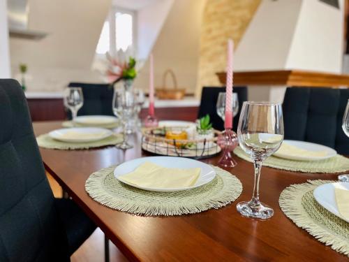 a wooden table with plates and glasses of wine at Central Apartment Stylovy Mezonet in Košice