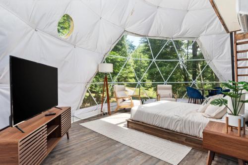 a room with a bed and a tv in a tent at Zen Dome - Romantic Retreat, Wifi & AC, Hot Tub, National Park 8 Min in Luray