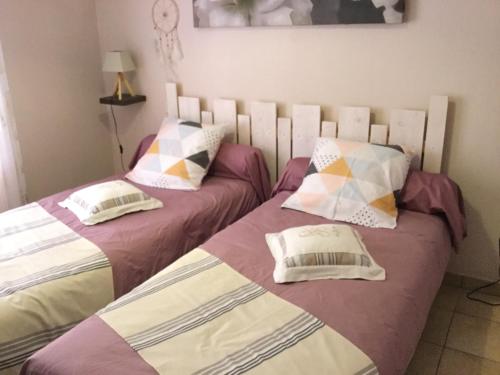 deux lits côte à côte dans une chambre dans l'établissement Les Oliviers, au Teich