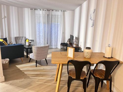 un salon avec une table et des chaises en bois dans l'établissement Appartement T3 proche remparts, à Avignon