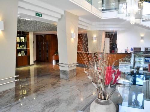 a lobby with a vase with flowers in it at Cristal Palace Hotel in Andria