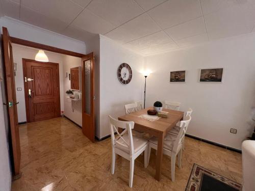 a dining room with a table and white chairs at Impecable piso a 300 mt del mar! in Puerto de Mazarrón
