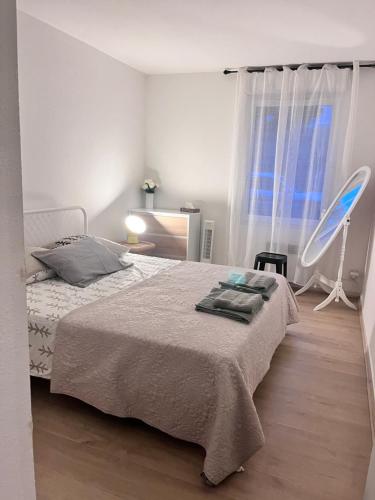 une chambre avec un lit, une chaise et une fenêtre dans l'établissement Appartement T3 proche remparts, à Avignon