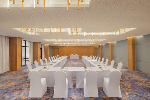 a conference room with white tables and white chairs at Courtyard by Marriott Goa Colva in Colva