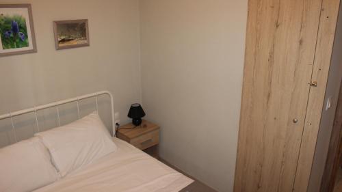 une chambre avec un lit et une table de chevet avec une lampe dans l'établissement A&B My Sweet Home 2, à Anatolí