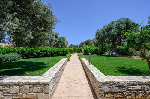 a stone path in a garden with a stone wall at Thyme Villa in Prínos