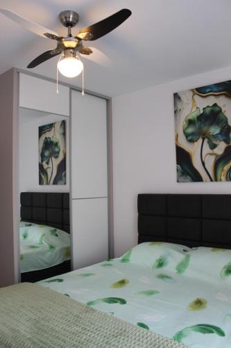 a bedroom with a bed and a ceiling fan at Apartman Nivalis in Čapljina