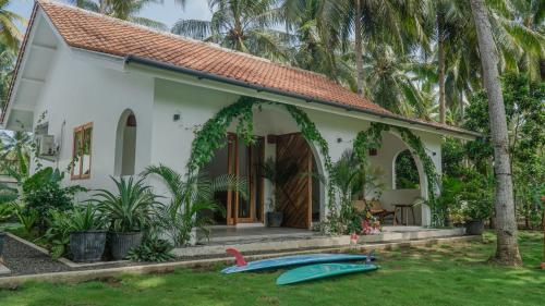 a house with two surfboards in front of it at Rumah Markisa Batukaras in Batukaras