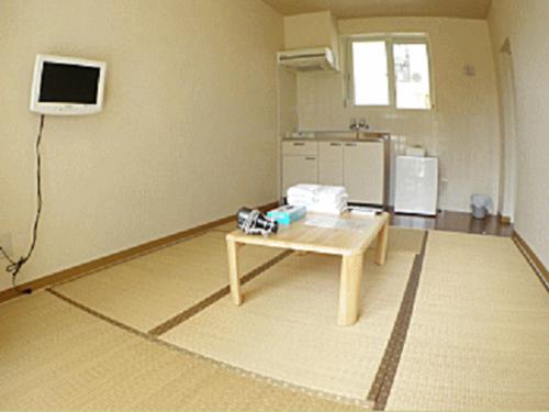 a room with a table and a tv on the wall at Cha Villa in Zamami