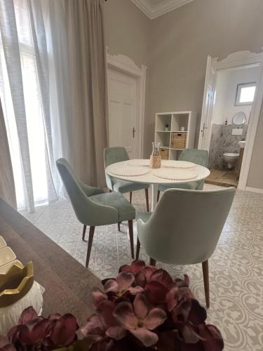 un soggiorno con tavolo e sedie di La Strada Central Apartament a Oradea