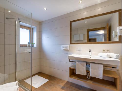 a bathroom with a sink and a shower at Appartements Bergland in Ellmau