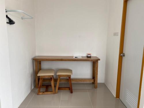 a small table with two stools in a room at Dino Homestay in Ban Muang Chum