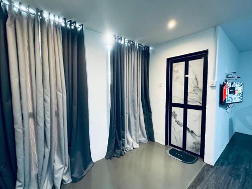 a room with curtains and a door and a window at Kuu Inn Hotel in Arau