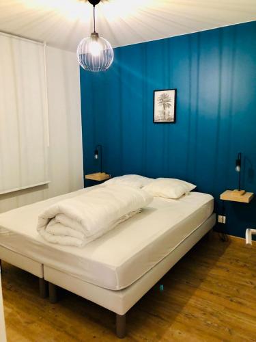 un lit dans une chambre avec un mur bleu dans l'établissement Villa 47, à Lège-Cap-Ferret