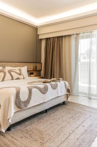 a bedroom with a large bed and a window at Villa Di Mare Seaside Suites in Ixia