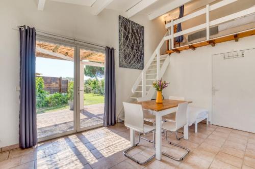 une salle à manger avec une table et des chaises et un escalier dans l'établissement Mas des Cypres - Mazet 5, à Saintes-Maries-de-la-Mer