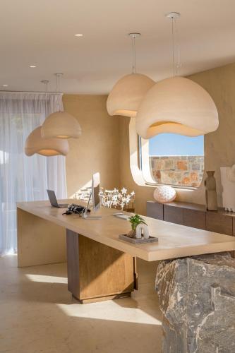 an office with a desk with a computer and pendant lights at Natali Apartments by Estia in Malia