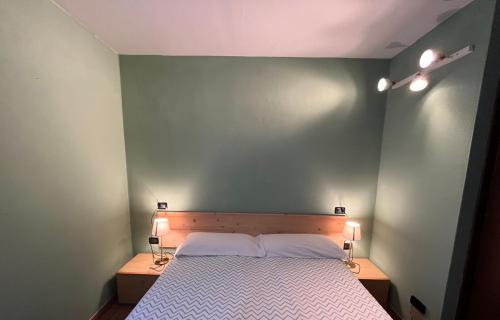 a bedroom with a bed with two lights on it at La Locanda dell'Oreste in Dizzasco