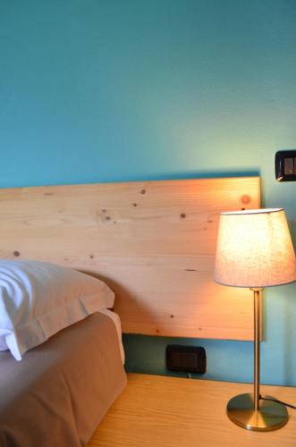 a bedroom with a bed with a lamp next to it at La Locanda dell'Oreste in Dizzasco