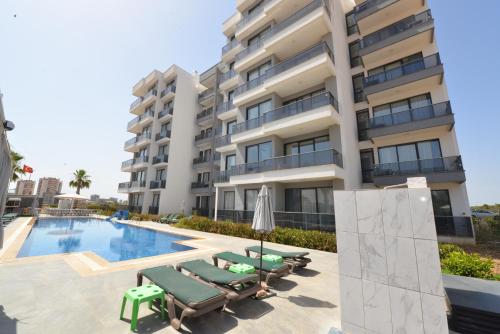 an image of a building with a swimming pool and chaises at Ethica Suite Luxury Houses in Aksu